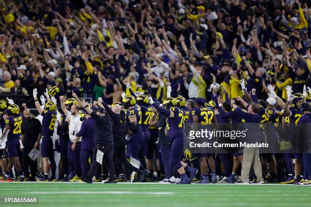 The Michigan Wolverines celebrate after a touchdown in the fourth quarter against the Washington Huskies during the 2024 CFP National Championship...
