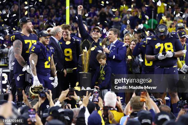 Head coach Jim Harbaugh of the Michigan Wolverines and his team celebrate after defeating the Washington Huskies during the 2024 CFP National...