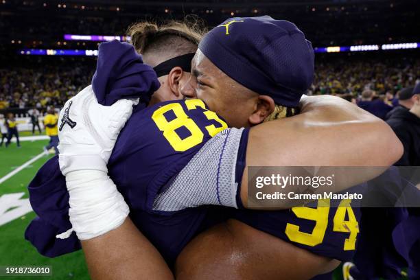 Zack Marshall of the Michigan Wolverines celebrates with Kris Jenkins after defeating the Washington Huskies in the 2024 CFP National Championship...