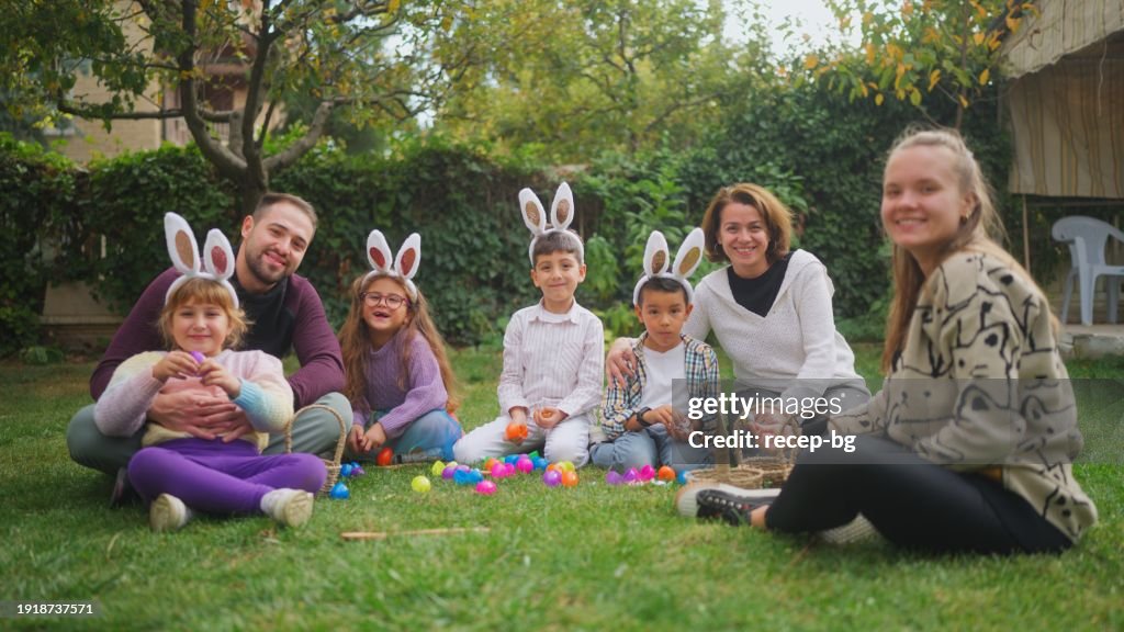Portrait of group of children and parents gathering at family garden for Easter event