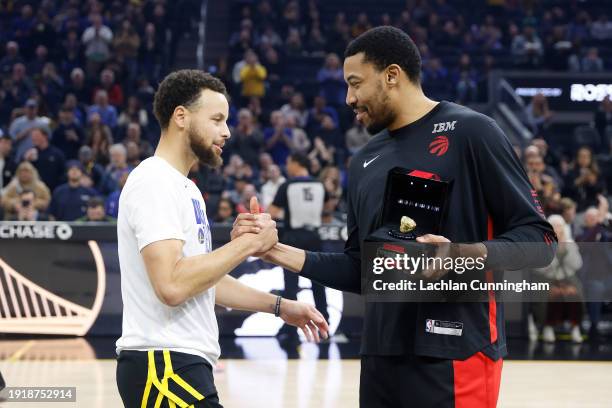 Former Golden State Warriors player Otto Porter Jr. #32 of the Toronto Raptors is presented with his 2021-22 championship ring by Stephen Curry of...