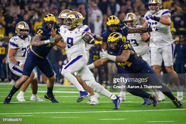 Michael Penix Jr. #9 of the Washington Huskies attempts to avoid a sack by Kris Jenkins of the Michigan Wolverines during the second half of the 2024...