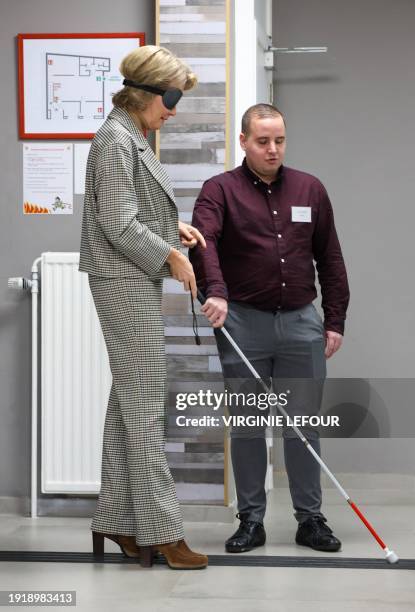 Queen Mathilde of Belgium walks with a cane during a simulation of blindless, as she visits the premises of the non-profit organization "Handicap...