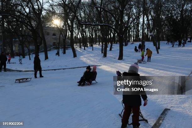Children ride sedges at Dyukovsky Park on a cold winter day.