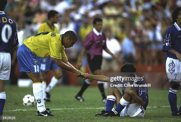 Ronaldinho of Brazil helps up a Japanese player during the Football event at the Centennial Olympic Games in Atlanta, Georgia. Japan beat Brazil 1-0....