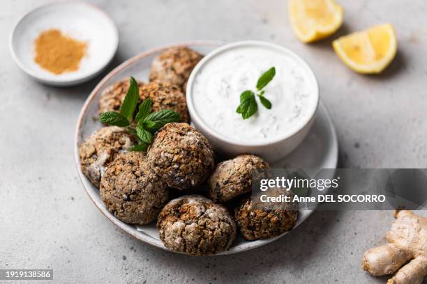 homemade veggie lentil balls with yogurt sauce and mint - vada stock pictures, royalty-free photos & images