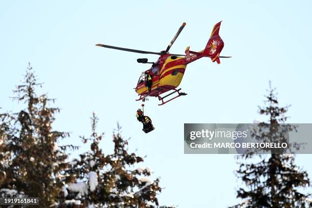 Rescuers arrive with a helicopter to evacuate France's Alexis Pinturault after he crashed during the men's Super-G event at the FIS Alpine Skiing...