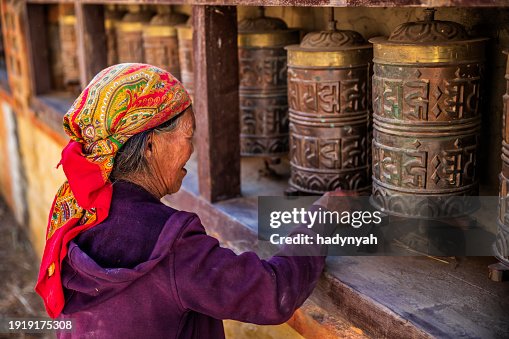 Old Tibetan woman turning the prayer wheels, Upper Mustang Old Tibetan woman turning the prayer wheels, Upper Mustang