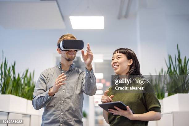 profesionales de negocios probando el nuevo software de realidad virtual en la oficina - innovación fotografías e imágenes de stock