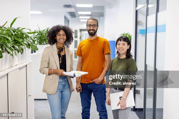 portrait of three businesspeople standing together in office - drie personen stockfoto's en -beelden