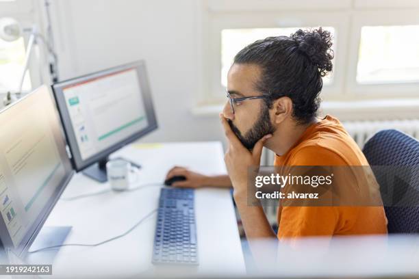 entrepreneur busy working on desktop computer at startup office - north african people stock pictures, royalty-free photos & images