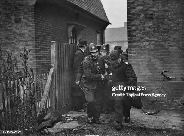 Dagenham resident is carried away from a property by a group of police officers during an eviction due to a rent strike, London, UK, November 1932.