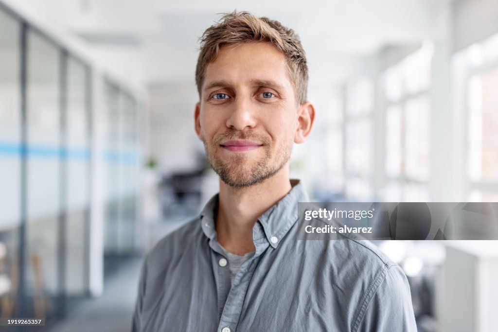 Close-up portrait of confident businessman standing in office
