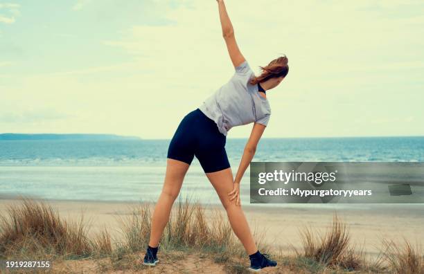 streching by the beach - white spandex shorts stockfoto's en -beelden