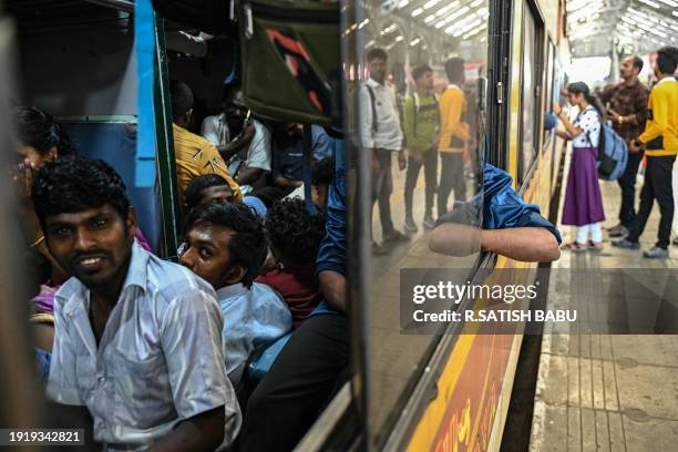 Passengers board a train to visit their respective hometowns ahead of the Hindu harvest festival of 'Pongal', in Chennai on January 12, 2024.