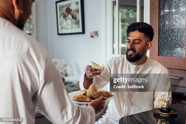 sharing the samosas - male muslims uk stockfoto's en -beelden