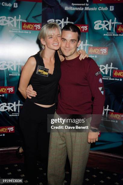 British broadcaster Zoe Ball and English singer Robbie Williams attend the Brit Awards nominations party at the Cafe de Paris, London, January 1998.