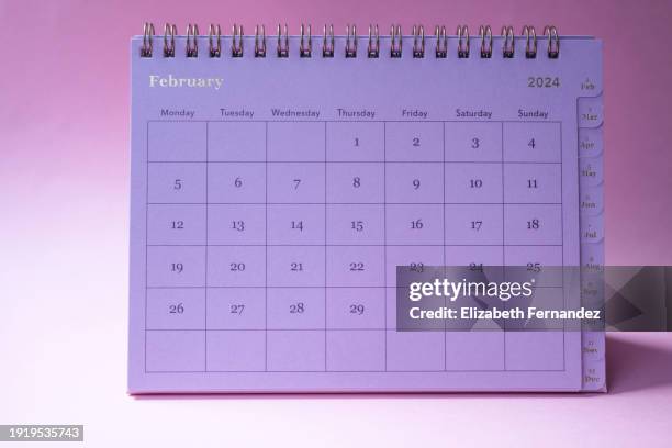 february 2024 desk calendar on pink background - febrero fotografías e imágenes de stock