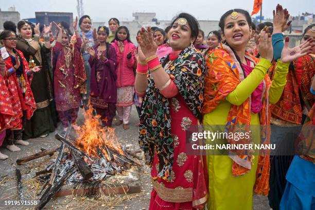 Women perform Punjabi folk dance 'Giddha' around a bonfire, on the eve of the 'Lohri' festival in Amritsar on January 12, 2024.