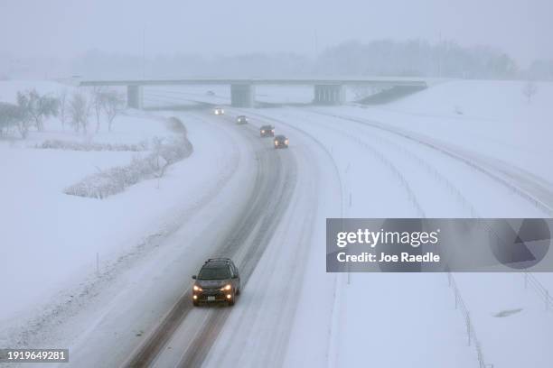 Vehicles drive slowly along I-80 as a snowstorm dumps several inches of snow on the area on January 09 in Des Moines, Iowa. The weather system is...