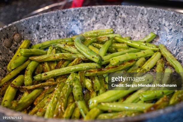 green beans being sautéed in a frying pan - comida gourmet stock pictures, royalty-free photos & images