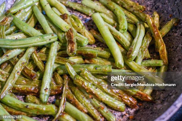 green beans being sautéed in a frying pan - comida gourmet stock pictures, royalty-free photos & images