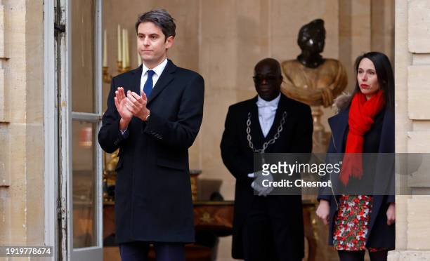 France's newly appointed Prime Minister, Gabriel Attal flanked by his Chief of staff, Fanny Anor applauds as his predecessor leaves at the end of a...
