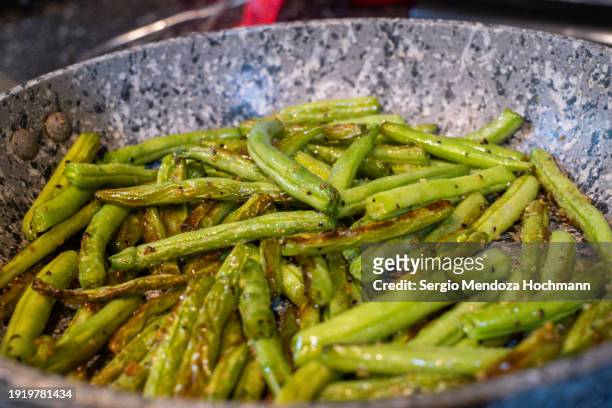 green beans being sautéed in a frying pan - comida gourmet 個照片及圖片檔