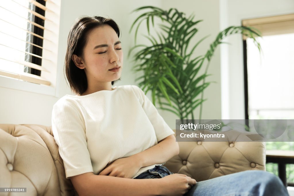 胃痛のあるアジア人女性
