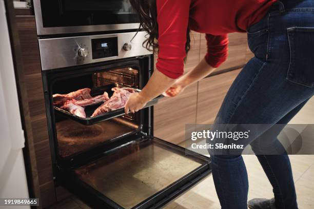 woman introducing a tray with baked lamb - lamb meat stock pictures, royalty-free photos & images