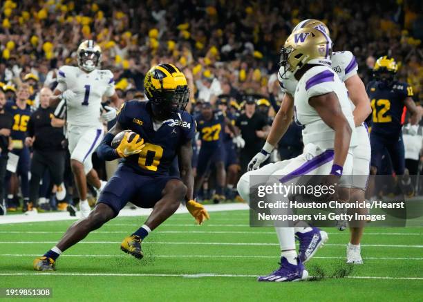 Michigan Wolverines defensive back Mike Sainristil returns the ball after intercepting a pass by Washington Huskies quarterback Michael Penix Jr....