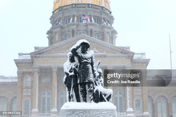 Snow covers a statue at the Iowa State Capitol building on January 09, 2024 in Des Moines, Iowa. A weather system is bringing the first winter...