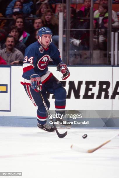 New York Islander's forward, Iain Fraser, rushes the puck towards the NJ Devil's zone during the game against the NJ Devils at the Meadowlands Arena...