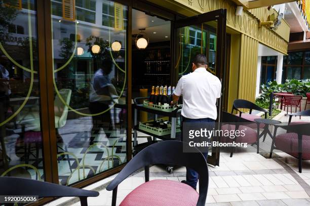 Worker pushes a cart into a bar onboard the Royal Caribbean Icon of the Seas cruise ship at PortMiami in Miami, Florida, US, on Thursday, Jan. 11,...