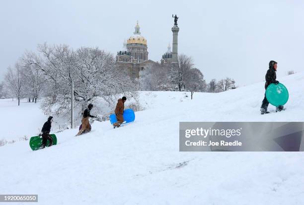 People enjoy sledding near the Iowa State Capitol building on January 09, 2024 in Des Moines, Iowa. A weather system is bringing the first winter...