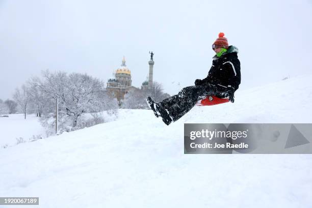 Jacob McPherren enjoys sledding near the Iowa State Capitol building on January 09, 2024 in Des Moines, Iowa. A weather system is bringing the first...