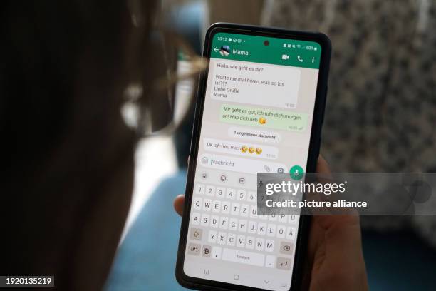 September 2023, Berlin: A young woman holds her smartphone in her hand and reads a WhatsApp message from her mom. Photo: Weronika Peneshko/dpa