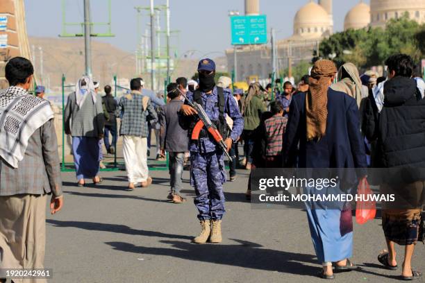 Fighter, loyal to Yemen's Huthi rebels, stands guard during a protest following US and British forces strikes, in the Huthi-controlled capital Sanaa...