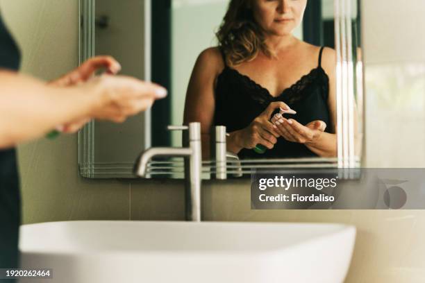 a beautiful middle-aged woman in a nightdress - vanity mirror stock pictures, royalty-free photos & images