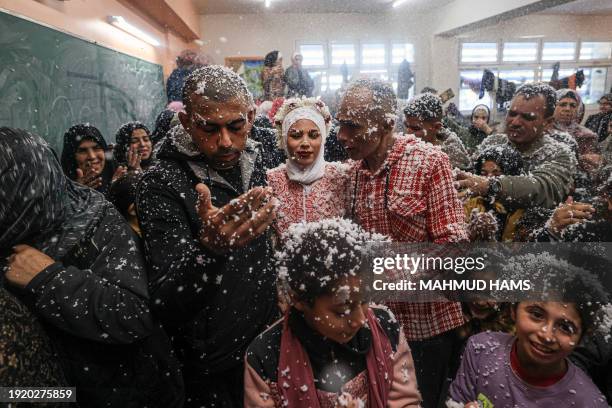 Palestinian newly-weds Afnan Jibril and Mustafa Shamlakh are surrounded by guests and relatives their wedding at the UNRWA School in the al-Salam...