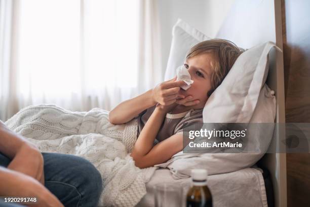 sick little boy with flu, cold, coronavirus, bronchitis or pneumonia, virus or infection blowing nose - cold virus stock pictures, royalty-free photos & images