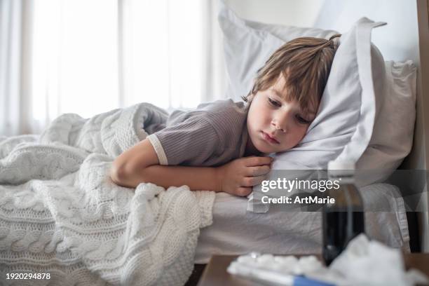 bambino a letto malato di raffreddore, influenza, polmonite, virus o infezione con qualche medicinale nelle vicinanze - mal di gola foto e immagini stock