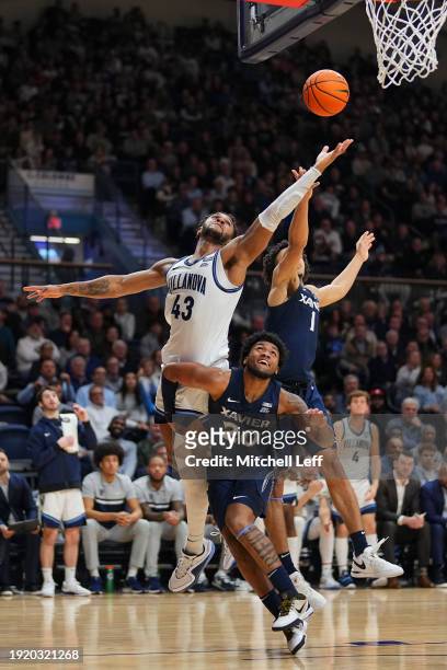 Eric Dixon of the Villanova Wildcats battles for a rebound against Dayvion McKnight and Desmond Claude of the Xavier Musketeers at Finneran Pavilion...
