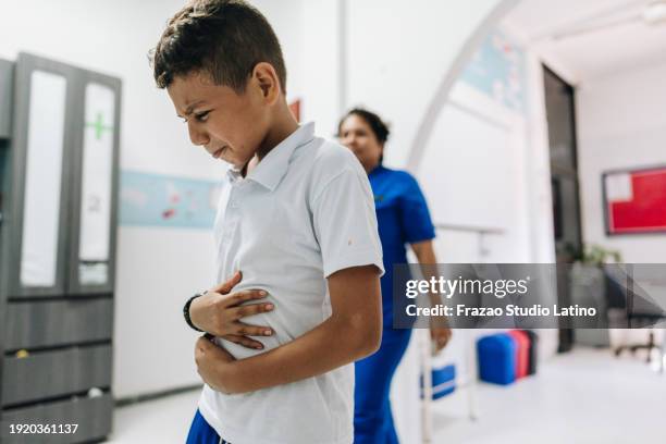 child boy with stomach pain at outpatient clinic - stomach pain stock pictures, royalty-free photos & images