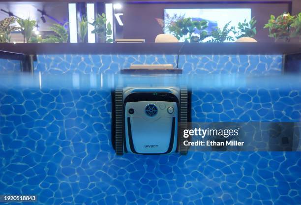 Wybot S2 robotic pool cleaner climbs the wall of a display pool as it automatically returns to the waterline at the Wybot booth during CES 2024 at...