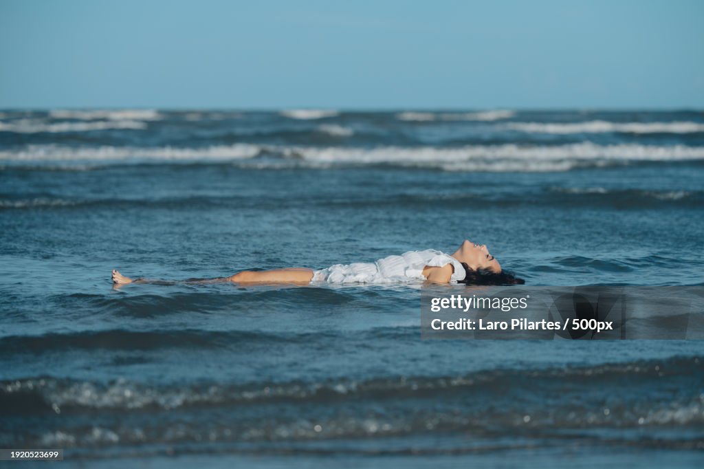 Side view of young woman floating on back while swimming in sea,Port Aransas,Texas,United States,USA
