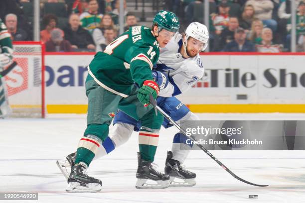 Joel Eriksson Ek of the Minnesota Wild handles the puck with Anthony Cirelli of the Tampa Bay Lightning defending during the game at the Xcel Energy...