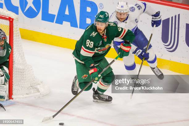 Frederick Gaudreau of the Minnesota Wild skates with the puck while Steven Stamkos of the Tampa Bay Lightning defends during the game at the Xcel...