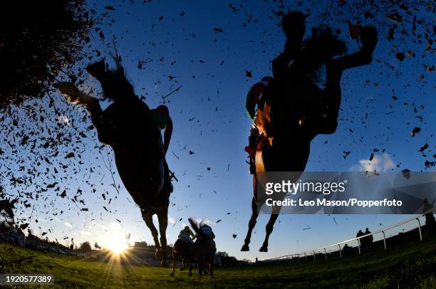 The dramatic view from beneath one of the fences taken with a remote control camera during the Tokio Marine Kiln Steeple Chase, as the sun sets over...