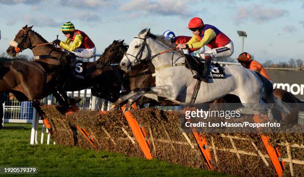 Horses and Jockeys traveling over the last fence during the Tokio Marine Kiln Steeple Chase, as the sun sets over the Betfair Tingle Creek Christmas...